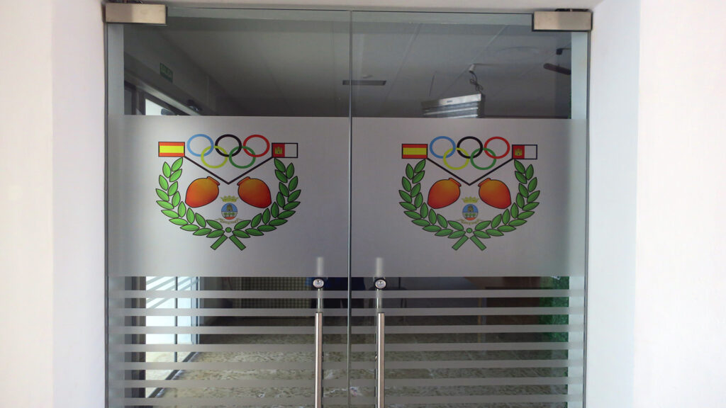 Puerta Principal de Cristal con el Logotipo del Club Las Tinajas