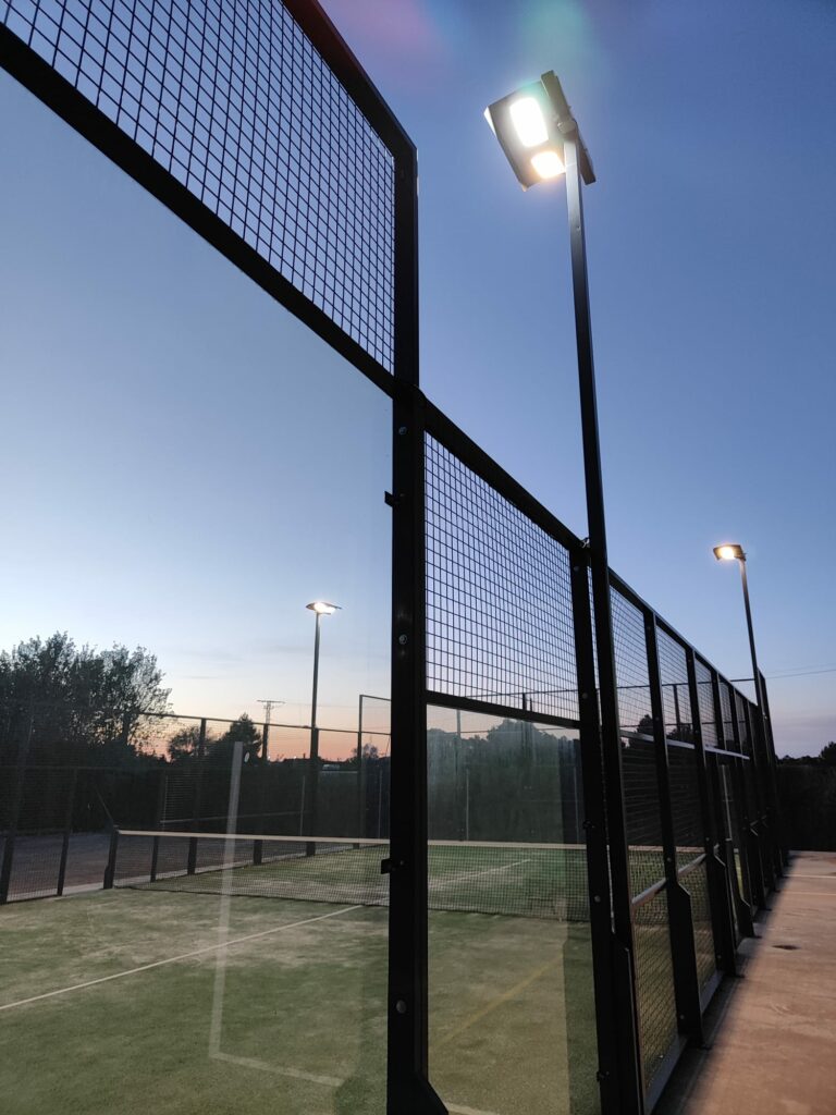 Los nuevos proyectores LED Roblan iluminando la pista de pádel al anochecer